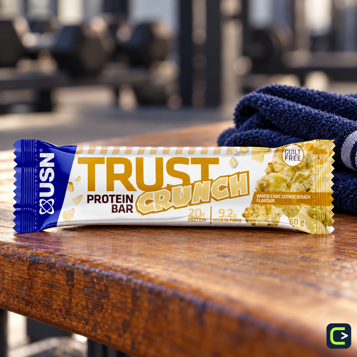 USN Trust Crunch White Chocolate Cookie Dough — une barre de 60 g sur un banc de sport, vendue par boîte de 12 — logo Le Coin du Sportif hors emballage